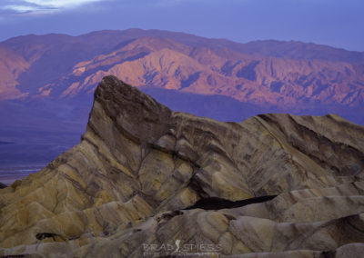 The Sunrise making the mountains glow behind Zabriskie point in Death Valley National Park.