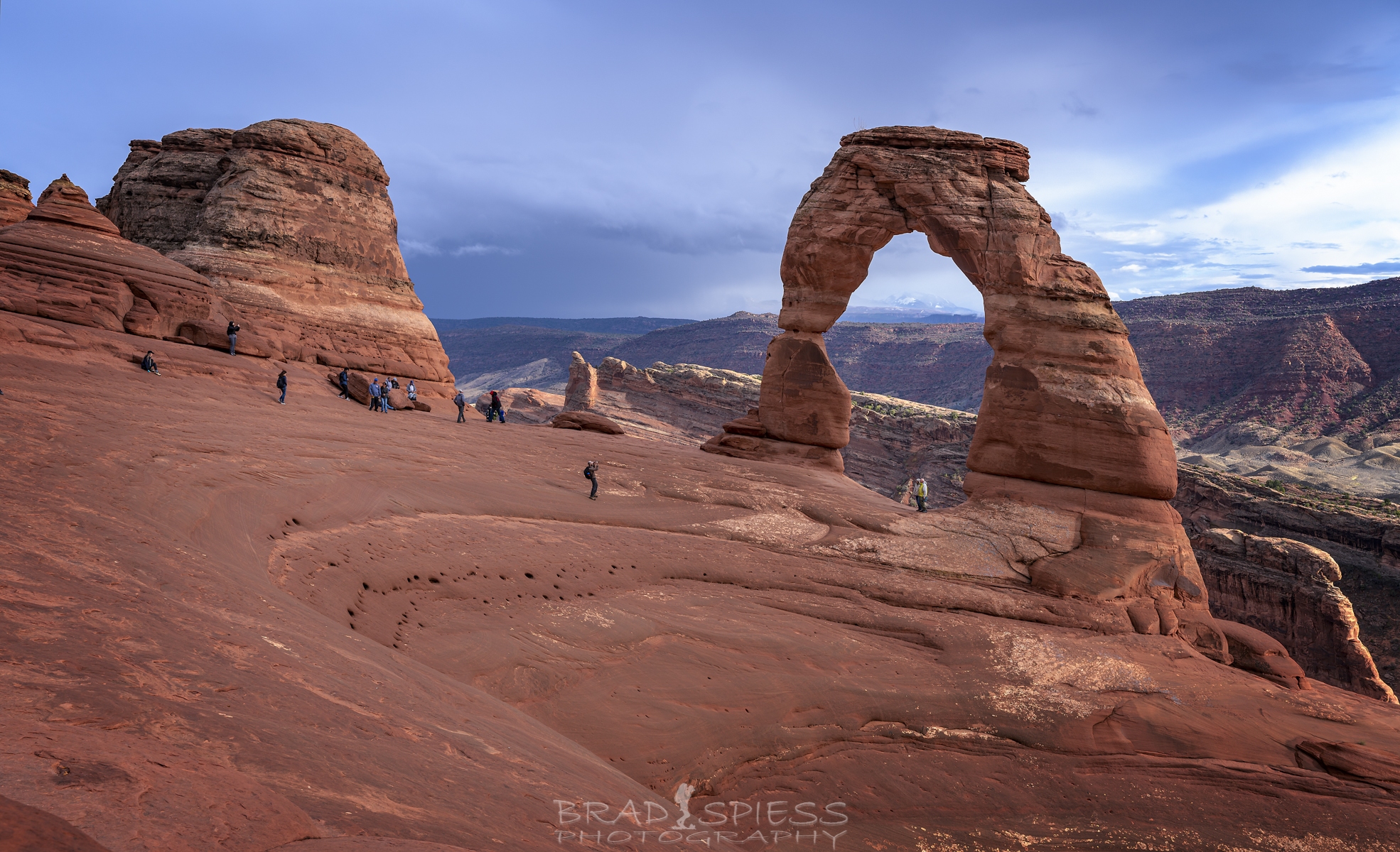 A tighter shot of Delicate Arch with people in the composition.