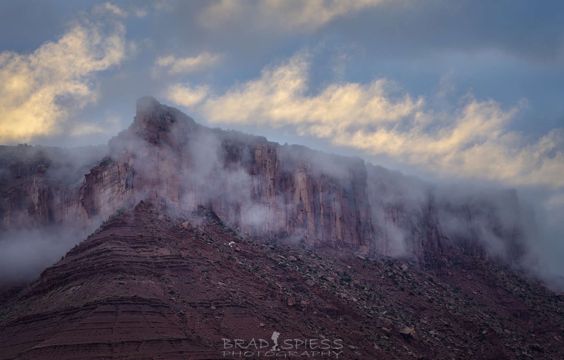 The sun playing with the clouds on Adobe Mesa across from Castleton Tower in Moab