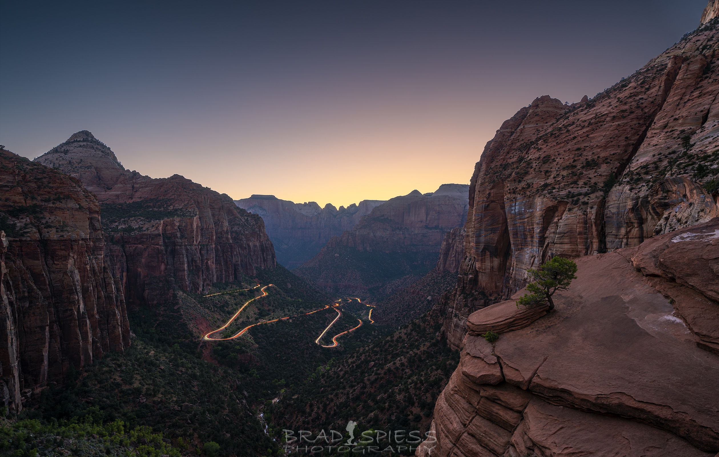 The cars leaving light trails below as seen from the Overlook Trail in Zion National Park